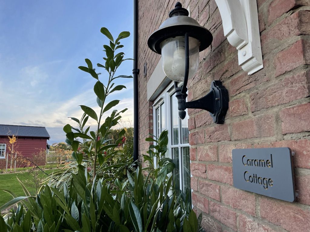 The Caramel Cottage name plaque and lamp beside the front door