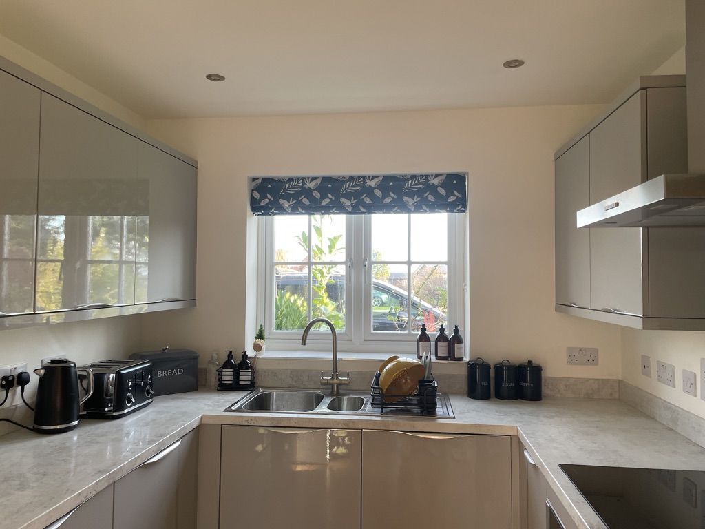 The fitted kitchen at Caramel Cottage, with sink under the window looking onto the garden