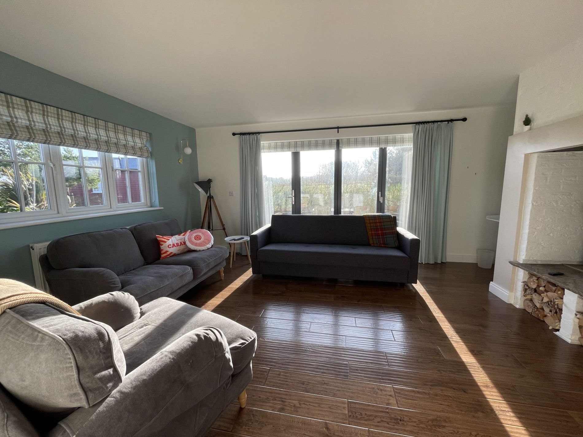 The living room at Caramel Cottage with sofas and doors onto the garden
