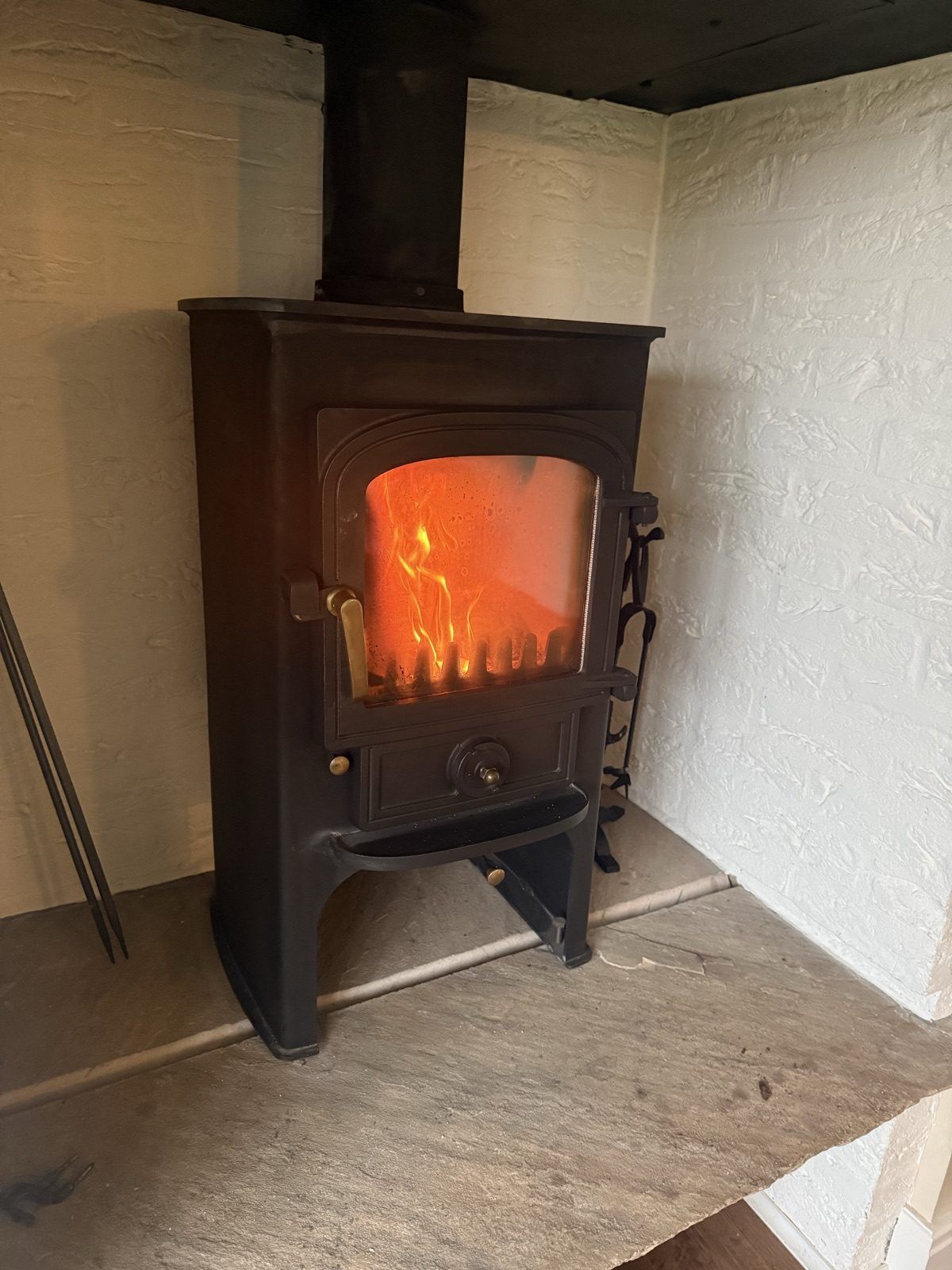 The log burner lit in the separate living room at Caramel Cottage