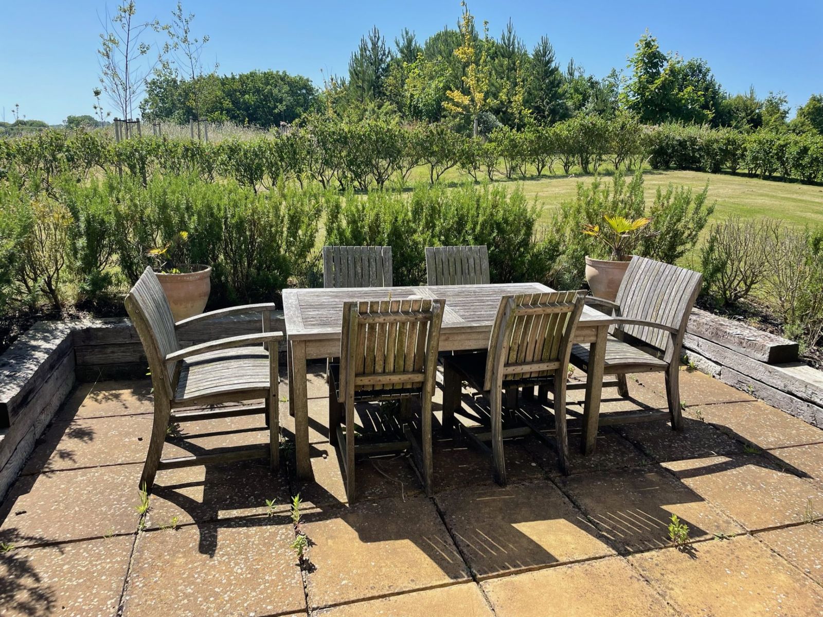 The patio table and six chairs at Caramel Cottage, looking out over the meadow behind