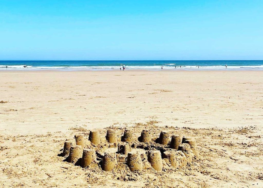 A cluster of sandcastles built on the wet sand at Hunmanby Gap beach