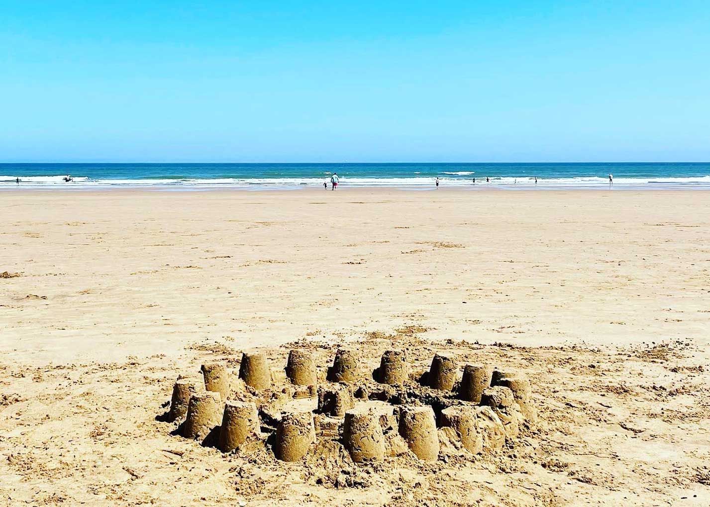 A cluster of sandcastles built on the wet sand at Hunmanby Gap beach