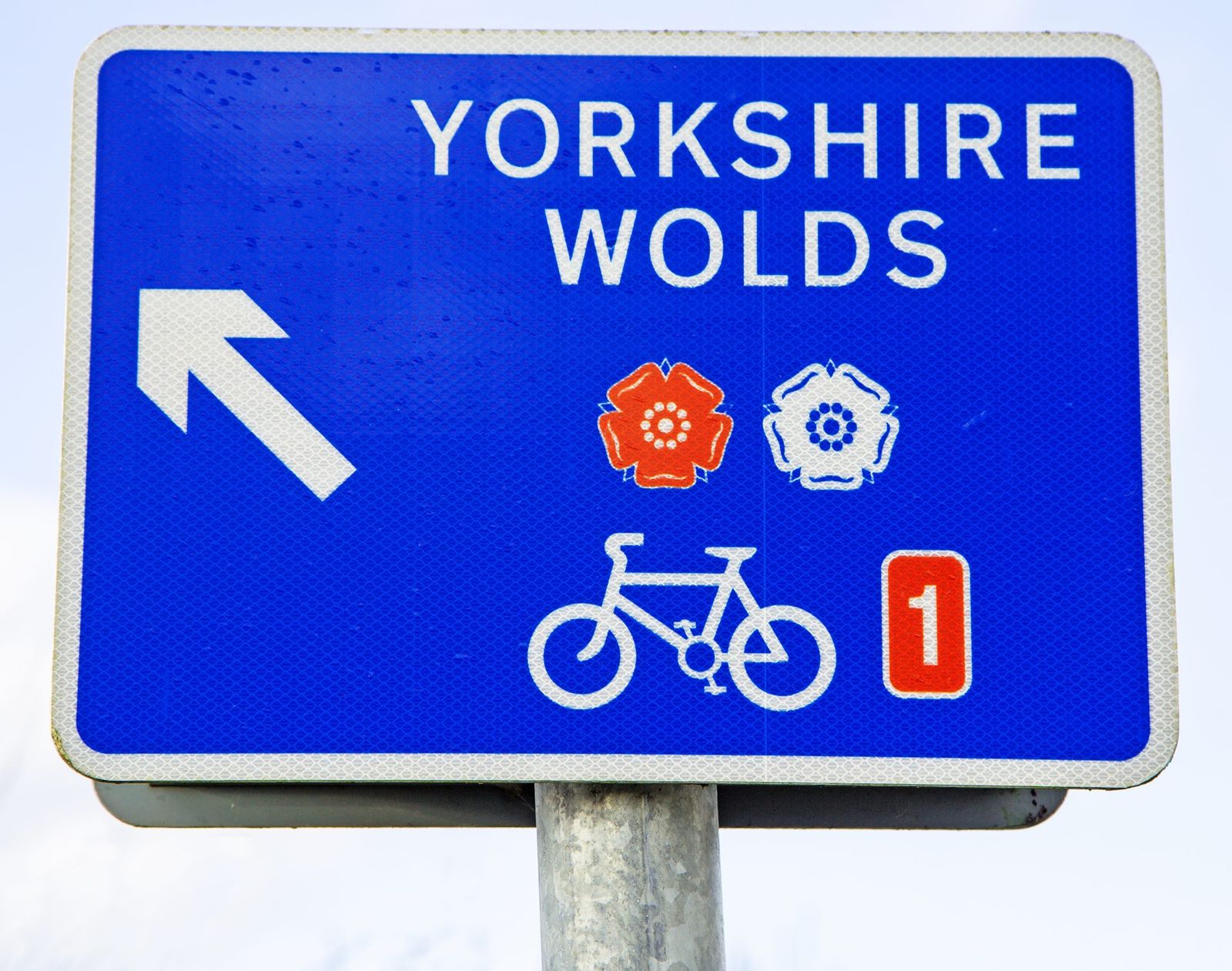 A blue Yorkshire Wolds cycle route sign carrying the National Cycle Network number 1